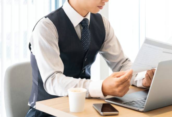 パソコンを操作する男性の画像。