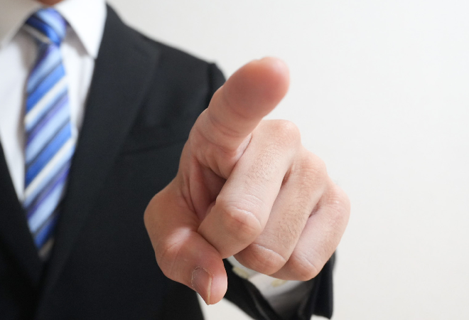 スーツ姿の男性が人差し指を向けている画像。