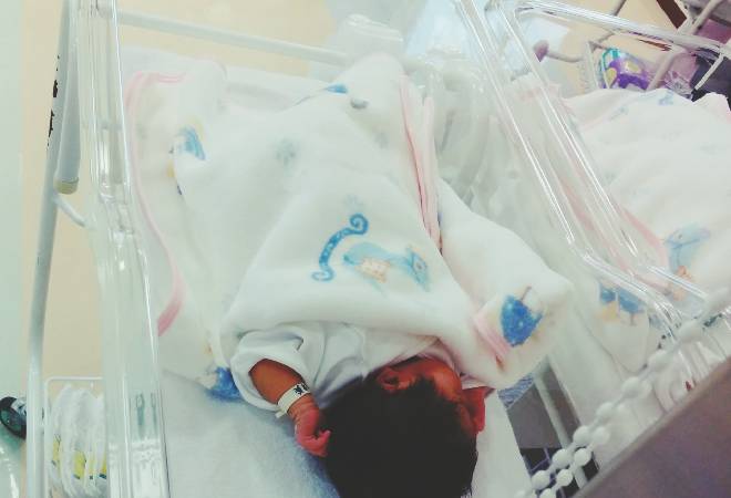 保育器で寝ている赤ちゃん。
